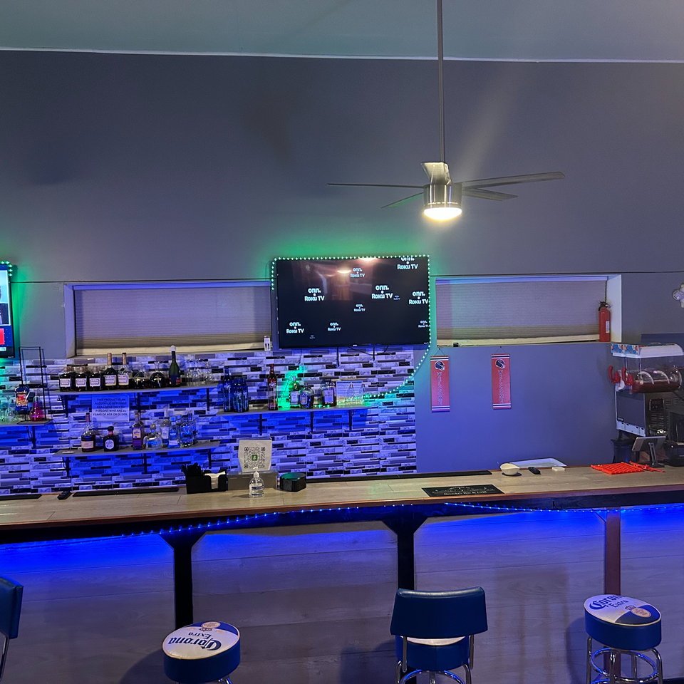 Brenda's Sports Bar & Grill features a bar with blue LED lighting, liquor bottles, and multiple TVs.