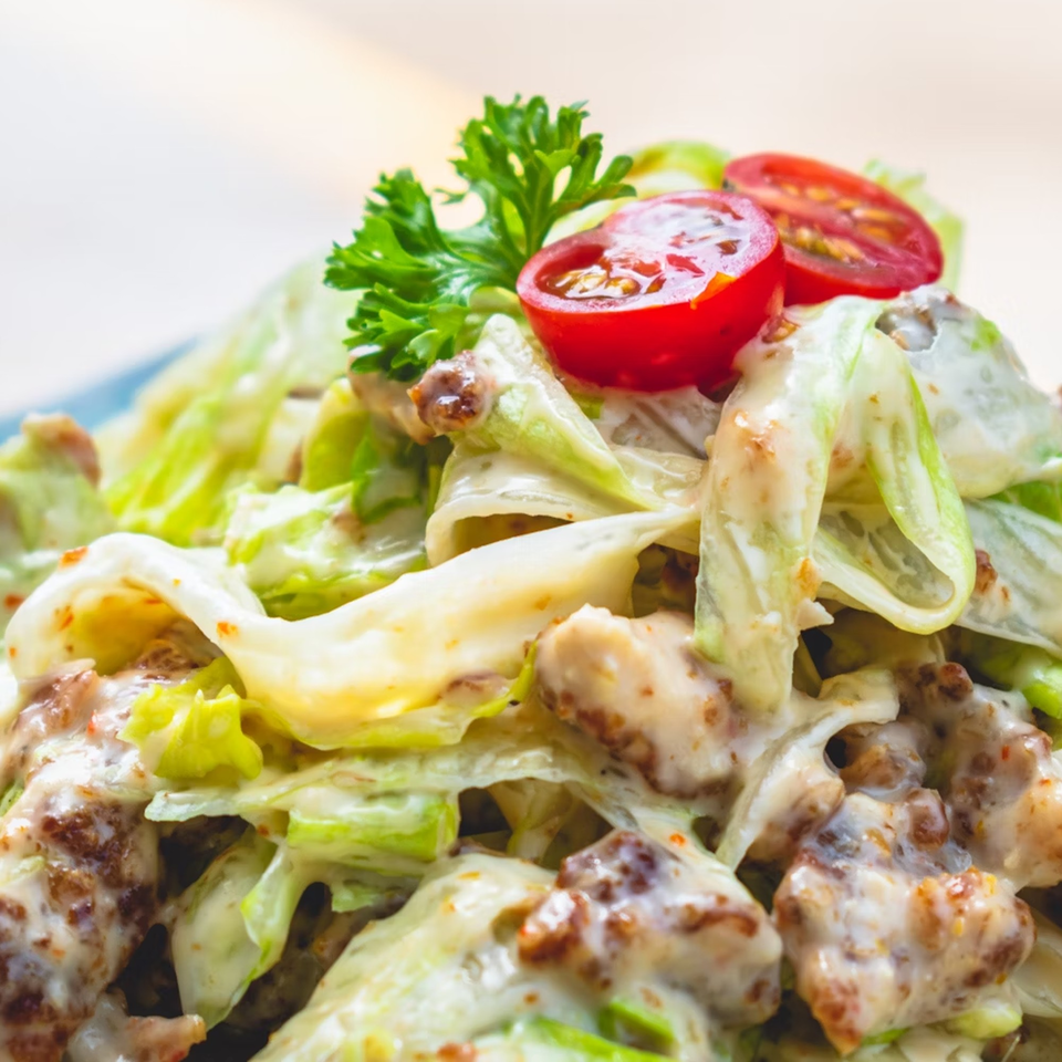 Close-up of a fresh salad with lettuce, cherry tomatoes, and creamy dressing at Brenda's.