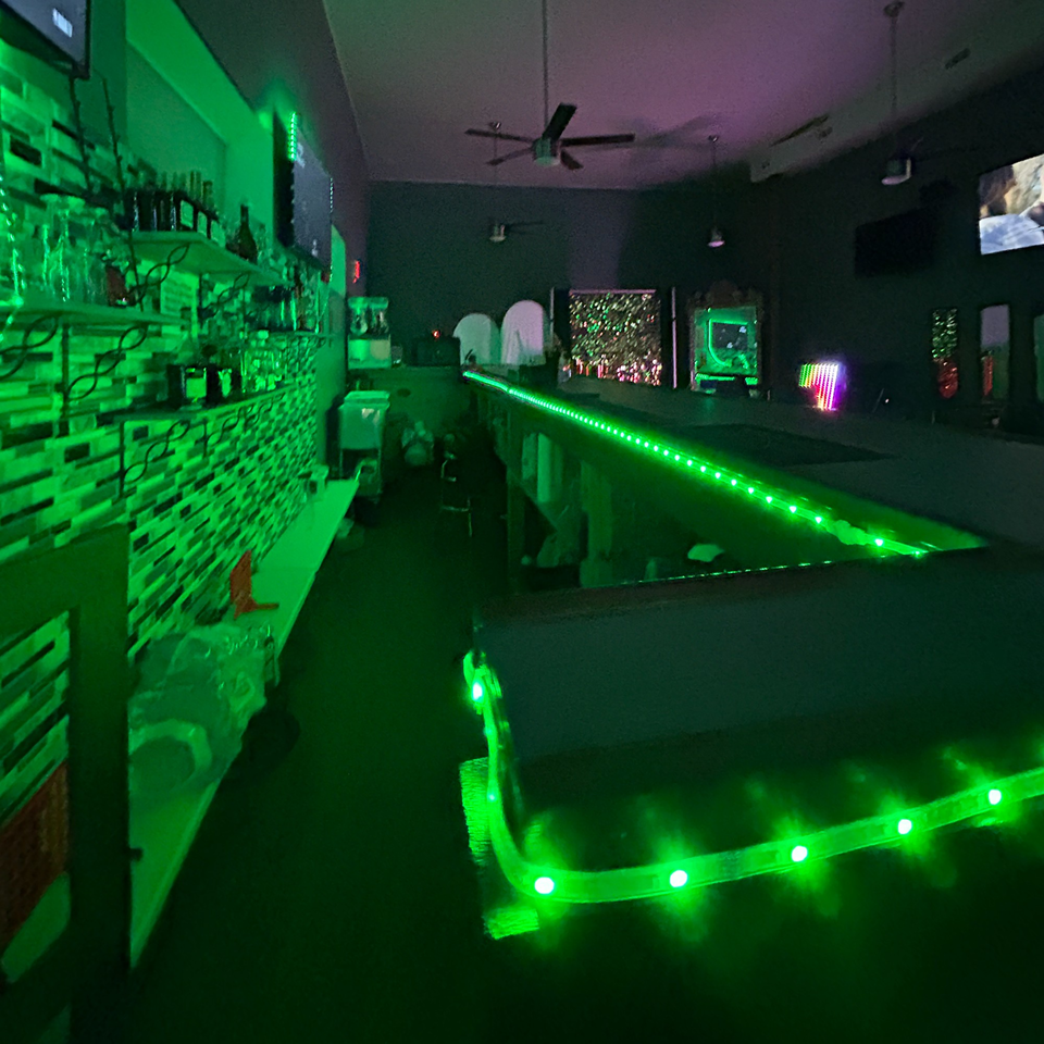 Brenda's Sports Bar & Grill interior with green LED lighting illuminating the bar and shelves.